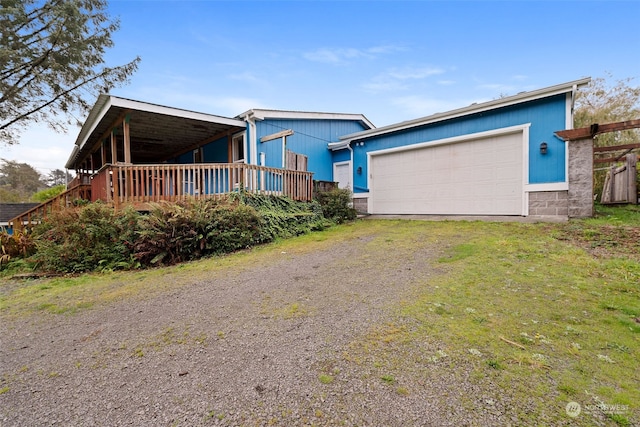 view of front facade with a front yard, a deck, and a garage