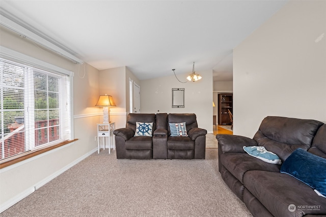 carpeted living room featuring a notable chandelier and vaulted ceiling