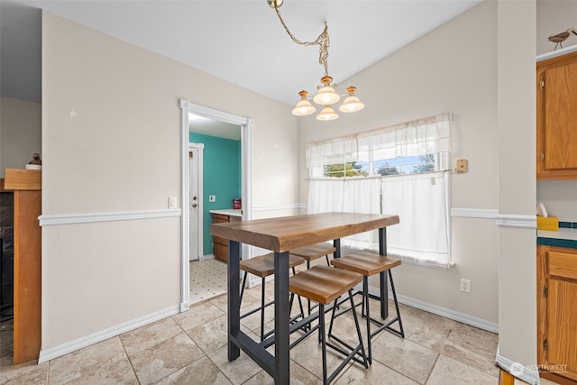 dining space featuring a notable chandelier and vaulted ceiling