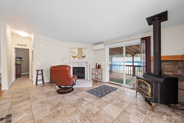 living room featuring a wall mounted air conditioner, lofted ceiling, and a fireplace