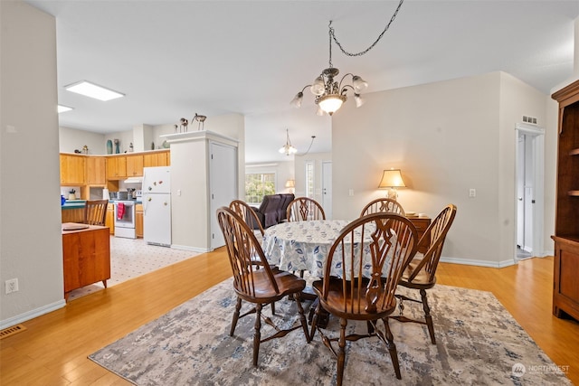 dining area featuring an inviting chandelier and light wood-type flooring