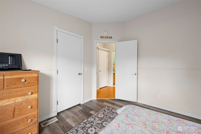 bedroom with dark wood-type flooring