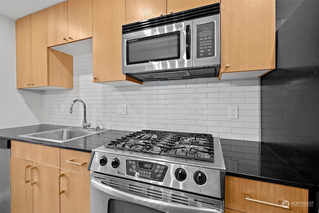 kitchen with sink, appliances with stainless steel finishes, and tasteful backsplash