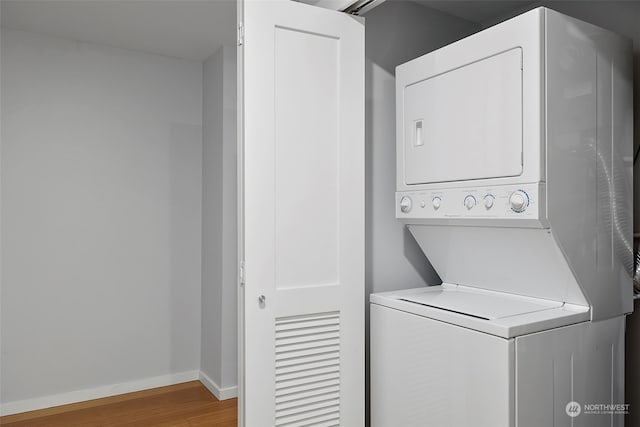 laundry area featuring hardwood / wood-style floors and stacked washer and dryer