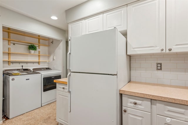 kitchen with decorative backsplash, white cabinets, washing machine and dryer, and white refrigerator