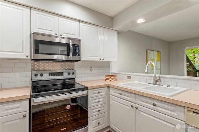 kitchen featuring tasteful backsplash, appliances with stainless steel finishes, sink, white cabinetry, and hardwood / wood-style flooring