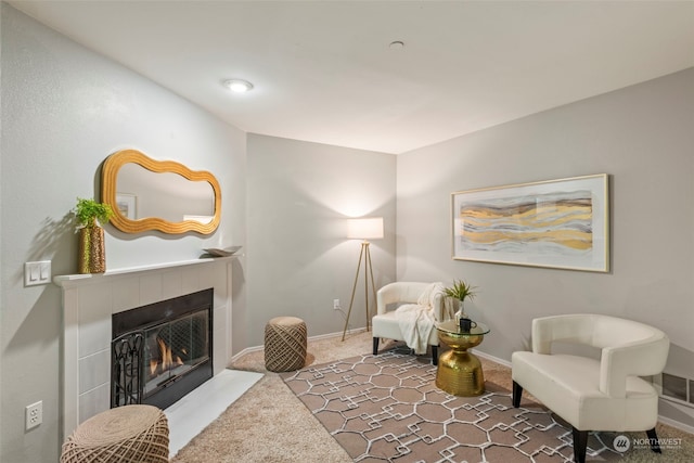 sitting room with carpet and a tile fireplace