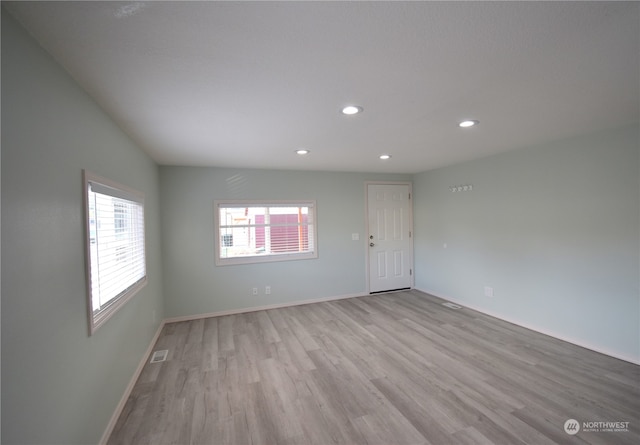 empty room with light hardwood / wood-style flooring