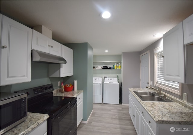 kitchen featuring black range with electric stovetop, sink, washer and clothes dryer, and white cabinets