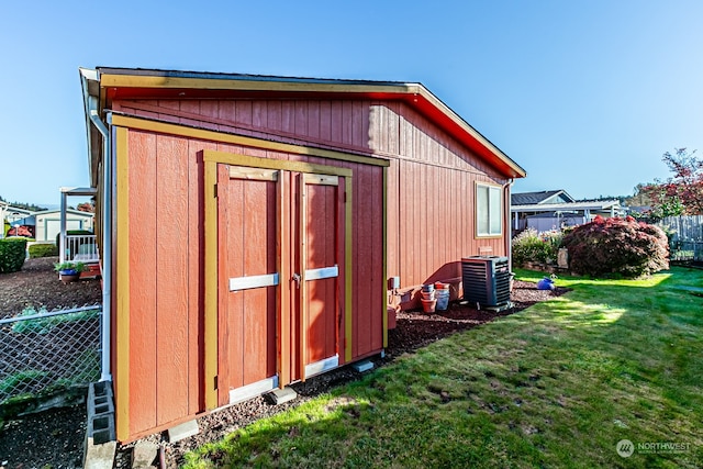 view of outbuilding featuring a yard and central AC