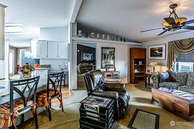 carpeted living room with ceiling fan, beamed ceiling, a skylight, and cooling unit