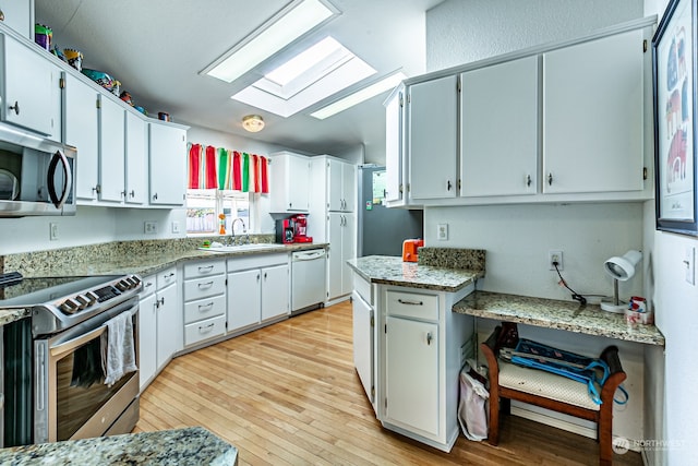 kitchen featuring appliances with stainless steel finishes, white cabinetry, light wood-type flooring, and a wealth of natural light