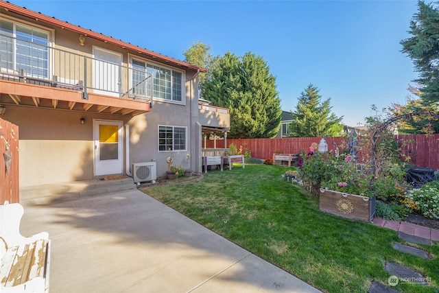 back of property with a patio, a lawn, a balcony, and ac unit