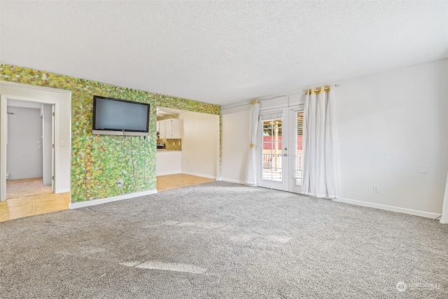 carpeted spare room featuring a textured ceiling