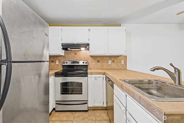 kitchen with light tile patterned flooring, white cabinetry, stainless steel appliances, and sink