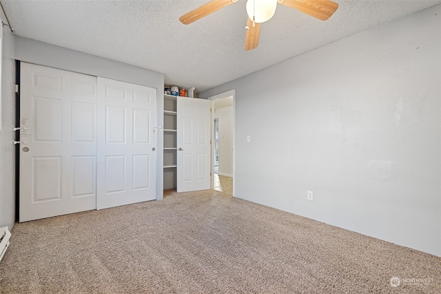 unfurnished bedroom featuring carpet flooring, a textured ceiling, a closet, and ceiling fan