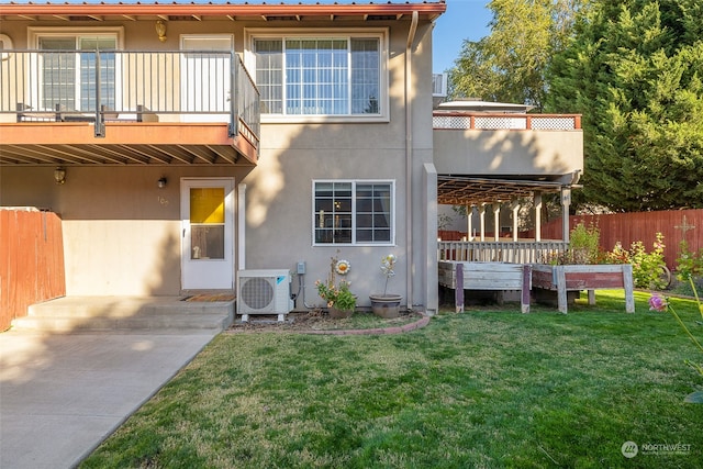 back of house with a yard, a balcony, and ac unit