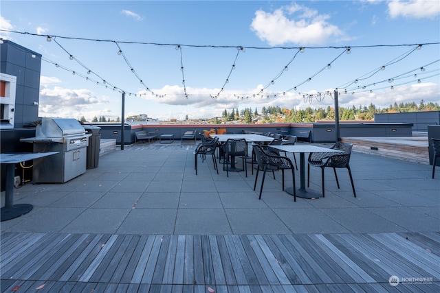 wooden deck with area for grilling and a patio area