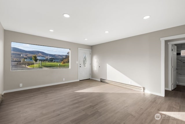 unfurnished living room with wood-type flooring and baseboard heating