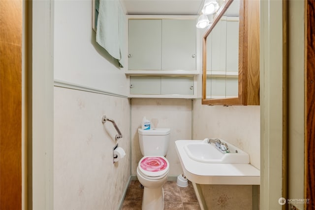 bathroom with sink, toilet, and tile patterned flooring