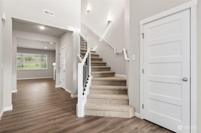 stairway featuring visible vents, wood finished floors, baseboards, and recessed lighting