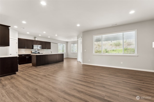 kitchen featuring dark wood finished floors, open floor plan, stainless steel appliances, and light countertops