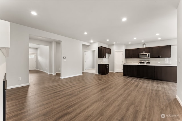 unfurnished living room featuring recessed lighting, baseboards, and dark wood-style flooring