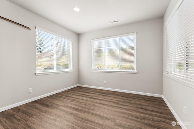 empty room featuring visible vents, wood finished floors, baseboards, and recessed lighting