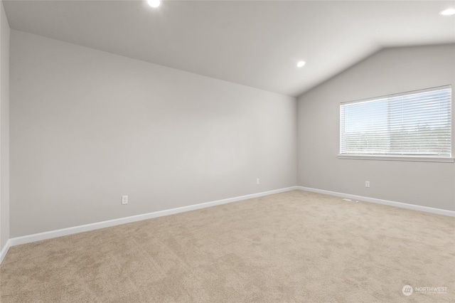 empty room with lofted ceiling, recessed lighting, light colored carpet, and baseboards