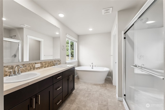 full bathroom with visible vents, a stall shower, a sink, double vanity, and decorative backsplash