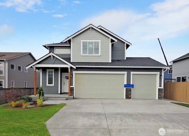 craftsman-style home with fence, concrete driveway, a front yard, stone siding, and an attached garage