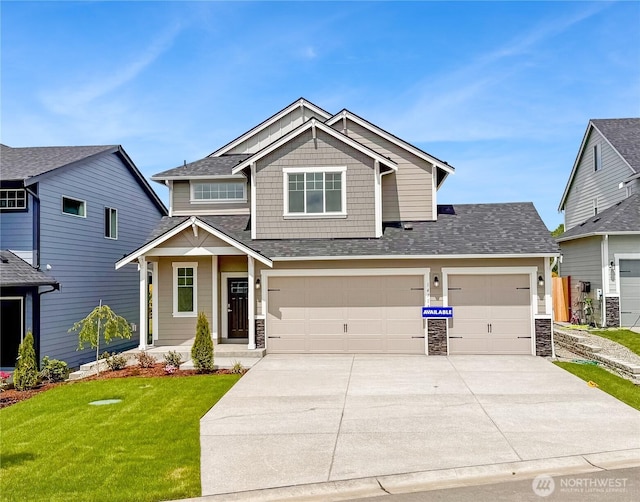 14714 88th Way SE Unit 3, Yelm, WA 98597 - craftsman-style house with driveway, a front yard, stone siding, an attached garage, and roof with shingles