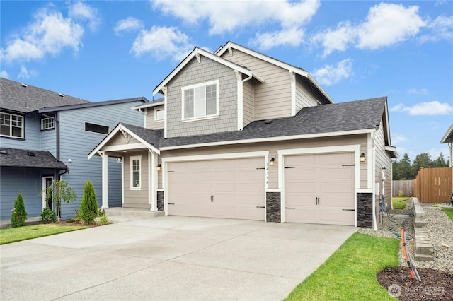14714 88th Way SE Unit 3, Yelm, WA 98597 - view of front facade with concrete driveway, a shingled roof, a garage, stone siding, and an attached garage