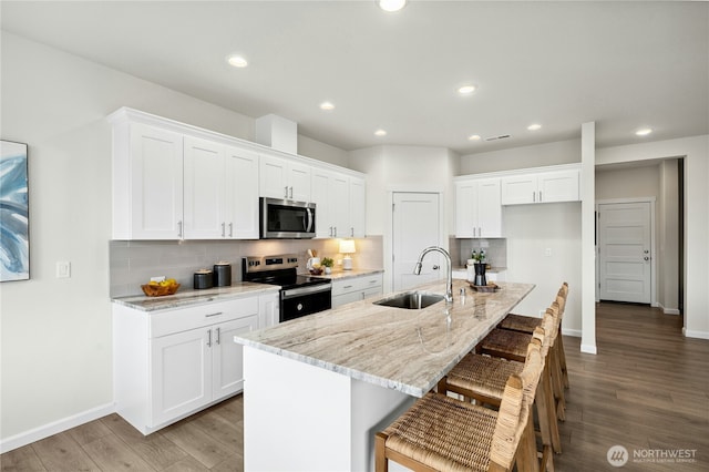14714 88th Way SE Unit 3, Yelm, WA 98597 - kitchen featuring stainless steel appliances, white cabinets, decorative backsplash, wood finished floors, and recessed lighting