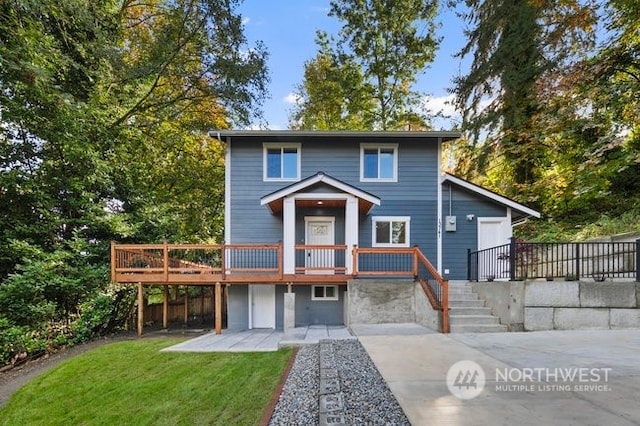 view of front of property featuring a deck and a front lawn