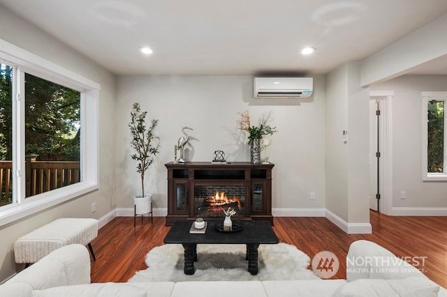 living area with a wall mounted air conditioner and dark hardwood / wood-style floors