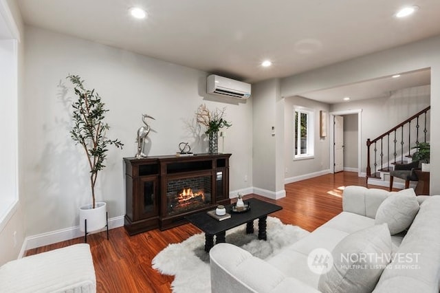 living room featuring dark hardwood / wood-style floors and an AC wall unit