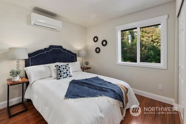 bedroom with dark wood-type flooring and a wall mounted AC