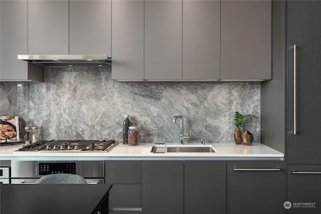 kitchen with gray cabinets, decorative backsplash, and sink