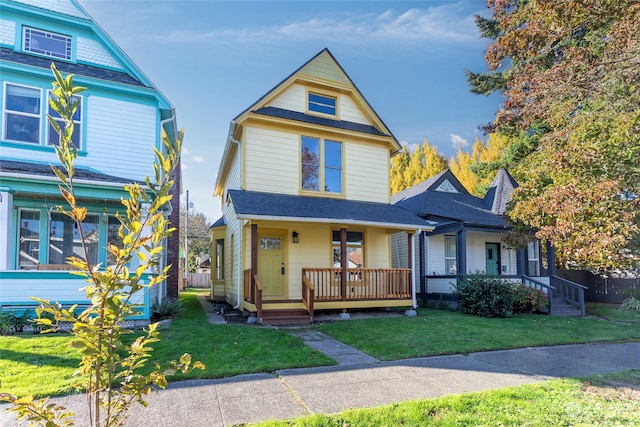 victorian-style house featuring a front yard and covered porch