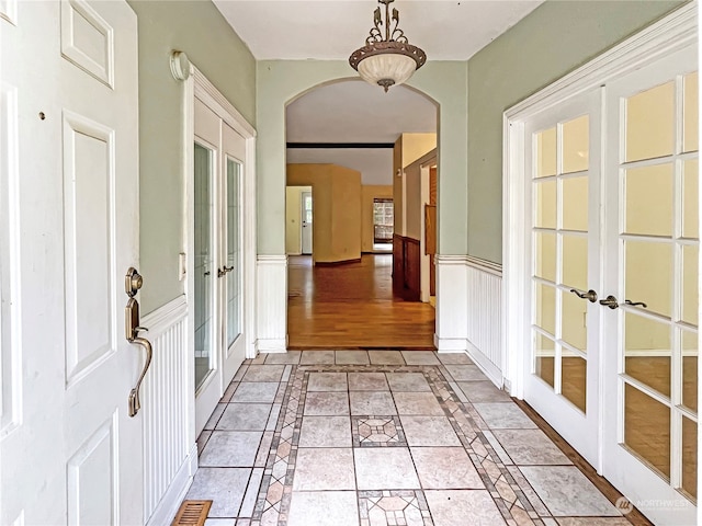 hall with french doors and light wood-type flooring