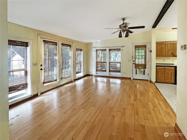 unfurnished living room featuring ceiling fan, light hardwood / wood-style flooring, and vaulted ceiling with beams