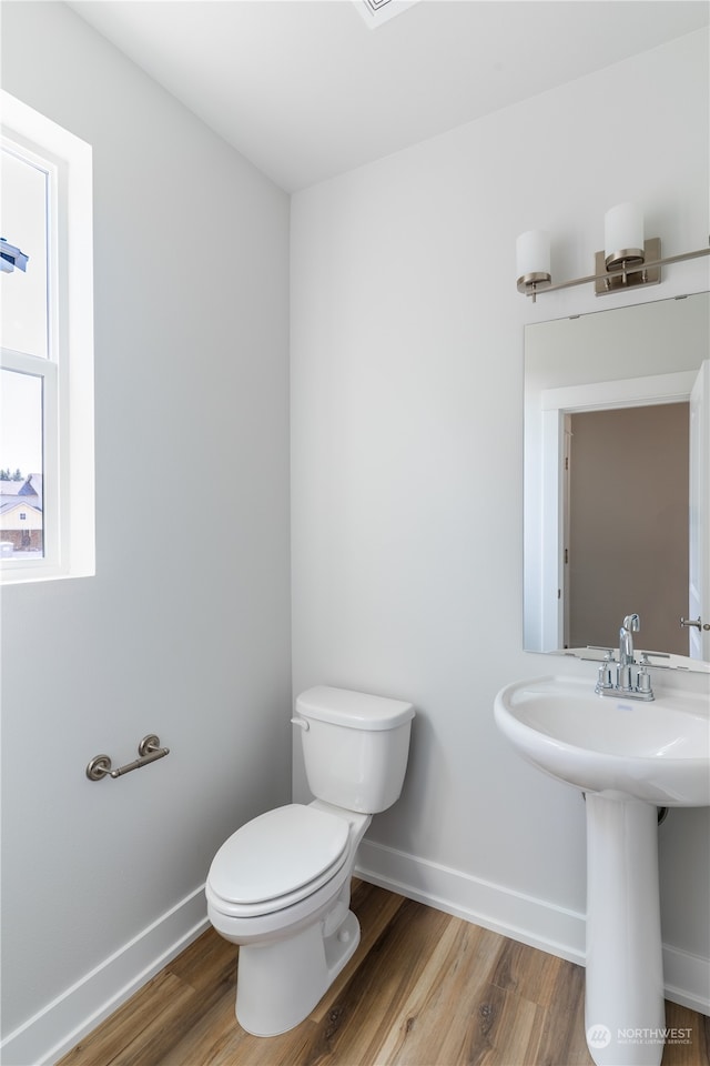 bathroom featuring hardwood / wood-style flooring and toilet