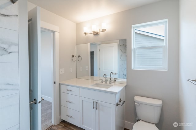 bathroom with hardwood / wood-style flooring, vanity, and toilet