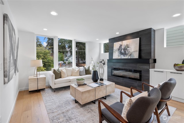 living room featuring a tile fireplace and light hardwood / wood-style floors