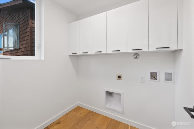 washroom featuring hookup for a gas dryer, electric dryer hookup, washer hookup, cabinets, and light hardwood / wood-style floors