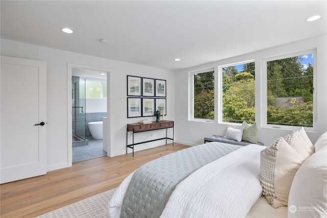 bedroom featuring ensuite bathroom and light hardwood / wood-style floors