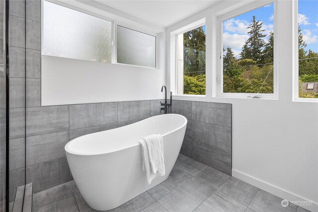 bathroom with tile walls and a bathtub