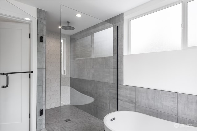 bathroom featuring shower with separate bathtub