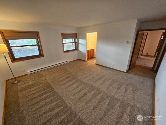 carpeted spare room featuring a baseboard heating unit